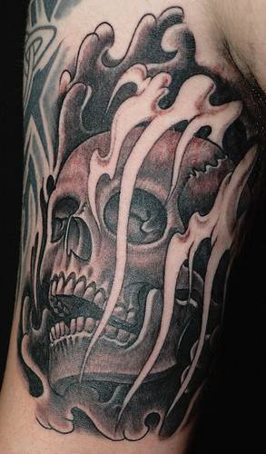 Skull in black smoke tattoo