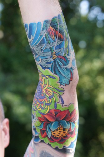 Colourful flower themed sleeve tattoo