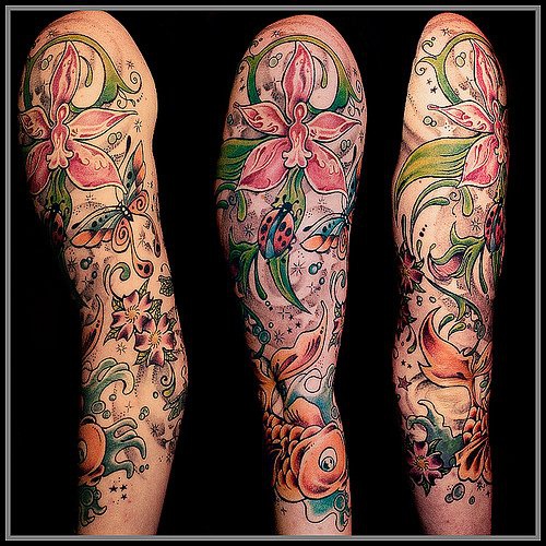 Tatuaje con flores multicolores mariquitas y peces dorados