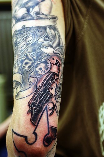 Skulls and guns sleeve tattoo