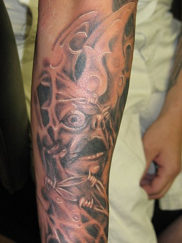 Monster in agony black sleeve tattoo