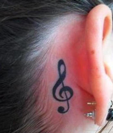 Treble clef behind ear tattoo