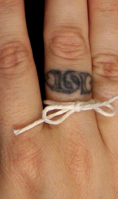 Tiny finger ring tattoo