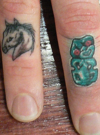 Tiny horse head finger tattoo