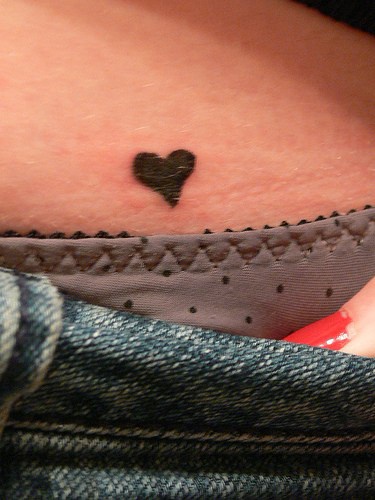 Tatuaje en la cadera, corazón negro diminuto