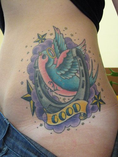 uccello con ferro di cavallo sul fianco tatuaggio