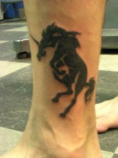 Small black unicorn on leg
