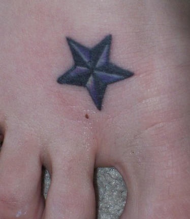 Piccola stella navile tatuaggio sul piede