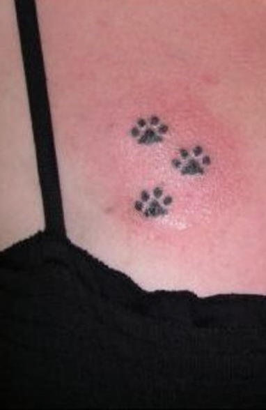 Pequeñas huellas del animal tatuaje en el pecho