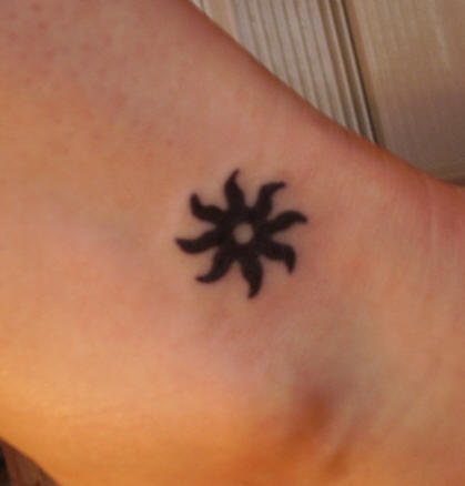Small tribal black sun tattoo