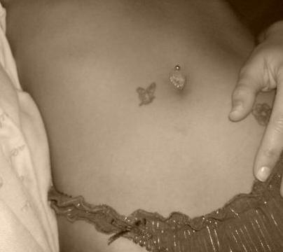 Small butterfly tattoo near tummy button