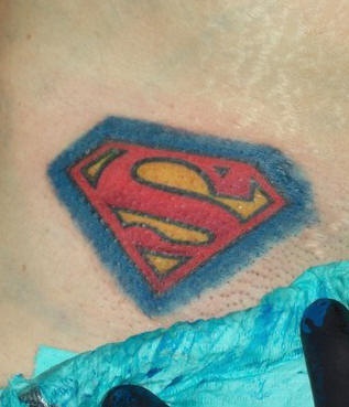 Coloured superman symbol tattoo
