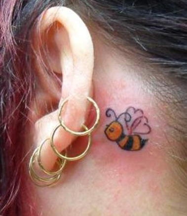 Precioso tatuaje abeja del dibujo animado  en color detrás de la oreja