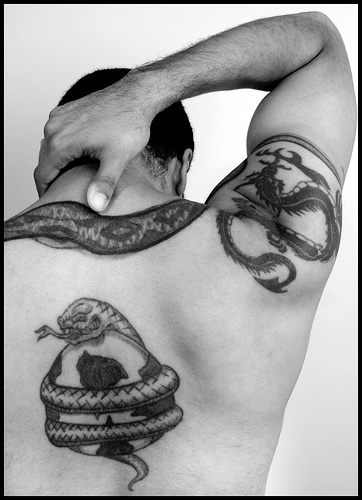 Serpent enroulant une balle de football le tatouage