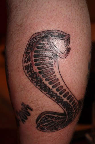 Tatuaggio carino sulla gamba il serpente con la bocca spalancata