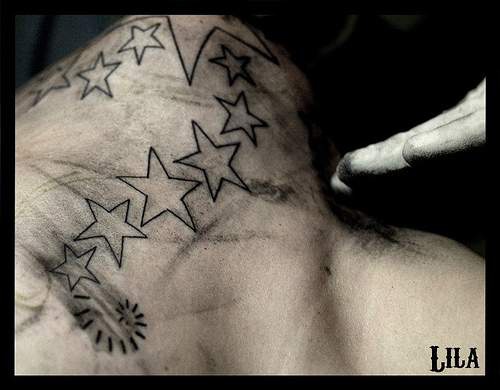 Línea de estrellas en tinta negra tatuaje en la espalda