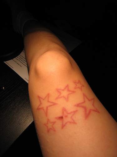 Red ink star tattoo on leg