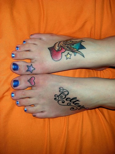 Tatuajes en los pies, golondrina con el corazón y un letrero