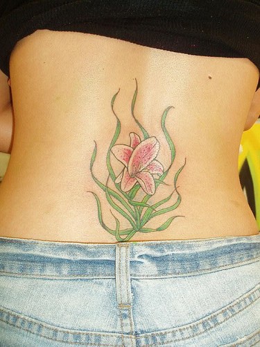 giglio rosa al lato basso sulla schiena tatuaggio