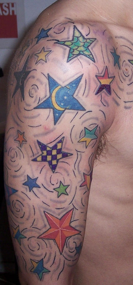 Tatuaje en el hombro, estrella de color y tamaño diferente
