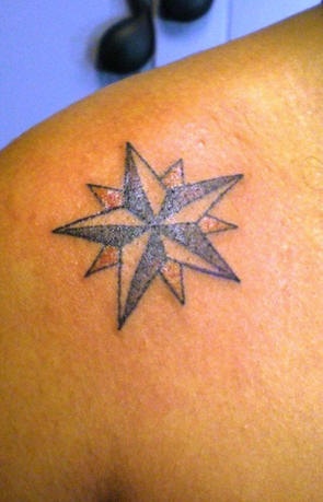 Tatuaje en hombro con estrella de muchos picos