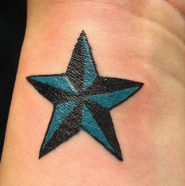 Estrella en tinta negra y azul tatuaje en la muñeca