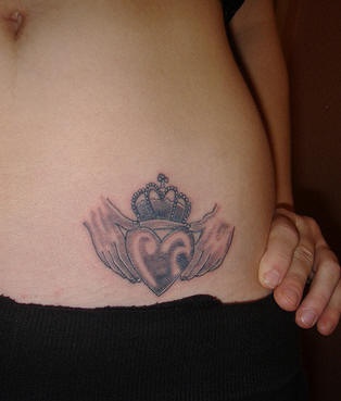 Bauch Tattoo vom gekrönten Herzen in Händen
