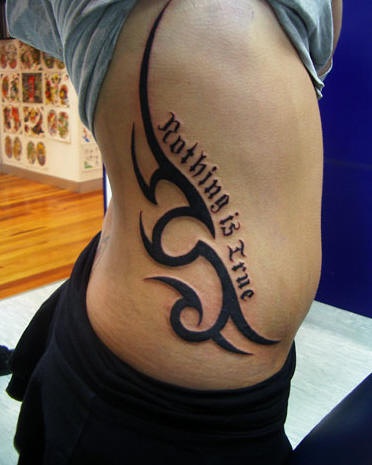 Tatuaggio grande sul fianco il disegno & la scritta &quotNOTHING IS TRUE"