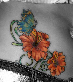 Stomach tattoo, butterfly flying above bright, orange flowers