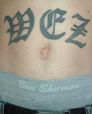 Stomach tattoo, three big letters, styled  inscription