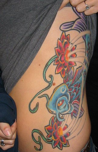 Stomach tattoo, blue catfish swimming in red shining flowers