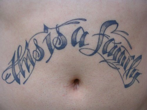 Tatuaggio grande sulla pancia la scritta &quotTHIS IS A FAMILY"