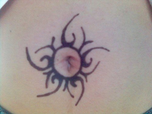 Stomach tattoo, black circle like sun around the navel