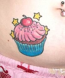 Tatuaje en vientre con apetitoso bizcocho, guinda y estrellas en color