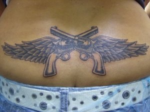 Bauch Tattoo von zwei gekreuzten Pistolen mit Flügeln
