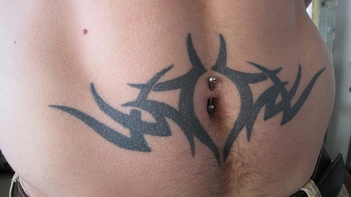 Stomach tattoo black pattern of wide checkmarks