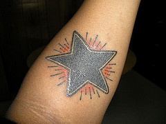 Black shining star tattoo