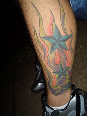 Tres estrellas en llamas tatuaje en la pierna