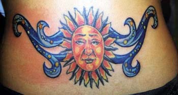 Pequeño símbolo del sol aspecto humano tatuaje en color en el bajo de  la espalda