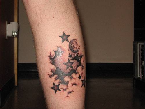Luna entre las nubes tatuaje en la pierna