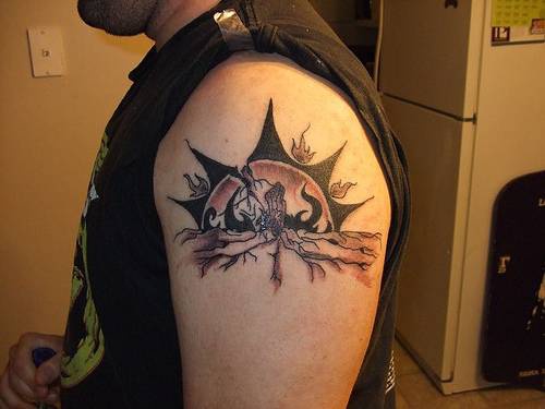 Sol negro con otros elemnetos tatuaje en el hombro