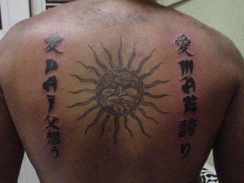 Sun and writings tattoo on back