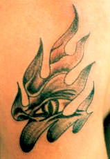 Evil eye in tribal flame tattoo