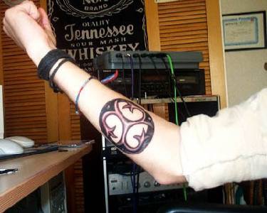 tatuaje con símbolo de trinidad en el brazo