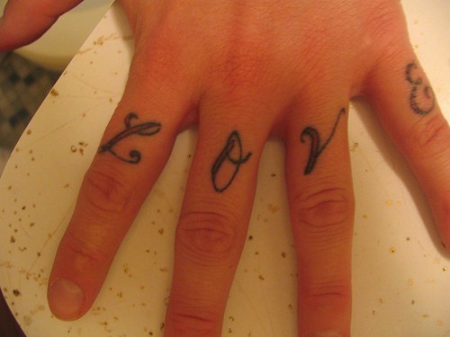 Stilisiertes Tattoo &quotLove" dünn und schön aufgeschrieben an Fingerknöcheln