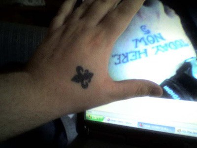 Tatuaje flor de lis en mano