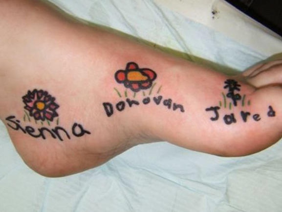 Tatuaje en pie de nombres de niños y flores
