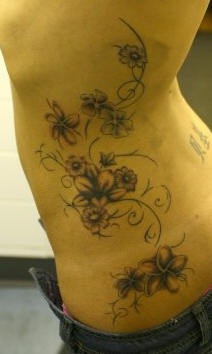 Tattoo von Rebe und Blumen an der Seite