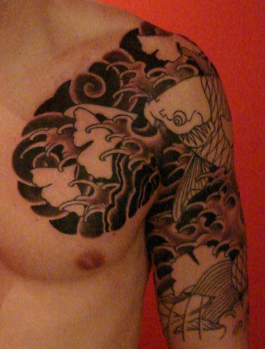 Poisson dans le tatouage de mer orageux sur le bras