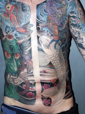 Demone Oni e carpe giapponese tatuati sulla pancia